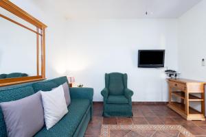 un soggiorno con divano verde e sedia di 107 LA ZARZA RURAL EXPERIENCE By Sunkeyrents a Santa Cruz de Tenerife