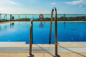 una piscina con agua azul y dos barras de metal en El pequeño paraíso, en Pilar de Jaravía