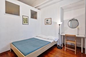 トリノにあるMoleloca - Casa Artisti 13のベッドルーム(ベッド1台、デスク、鏡付)