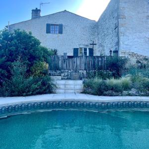 Nieul-le-Virouil的住宿－Naturo-gites，房子前面的房子和游泳池