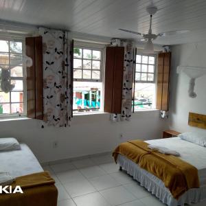 sypialnia z 2 łóżkami i 2 oknami w obiekcie O Pouso Sobrado w mieście Mucugê