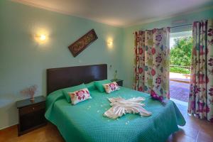 1 dormitorio con 1 cama con edredón verde en Montinho De Ouro, en Luz
