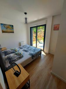 a bedroom with a bed and a table and a window at La Belle Vie en Alaric in Douzens