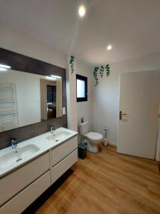 a bathroom with two sinks and a toilet at La Belle Vie en Alaric in Douzens