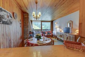 a living room with a table and a living room with a couch at Les Marmottes du Morzena in Morzine