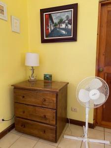 Zimmer mit Ventilator und Kommode mit Lampe in der Unterkunft Soleil Studio Ocotal in Sardinal