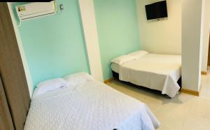 a room with two beds and a tv on the wall at Casa Arena San Andres in San Andrés +40 photos