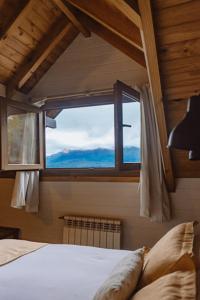 Schlafzimmer mit einem Bett und einem Fenster in der Unterkunft Cabañas Quetrihue in Villa La Angostura