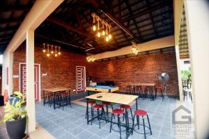 a room with tables and chairs and a brick wall at Gading Chalet in Kuala Terengganu