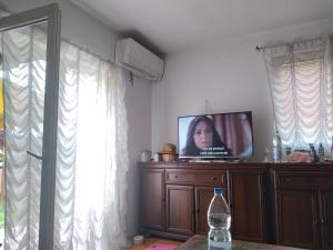 a living room with a tv on top of a dresser at Apartmani Safo 2 in Visoko