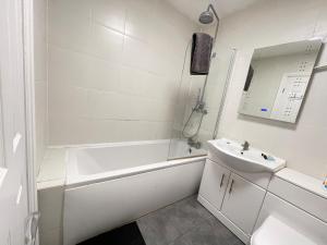 un bagno bianco con vasca e lavandino di Westminster House a Slough