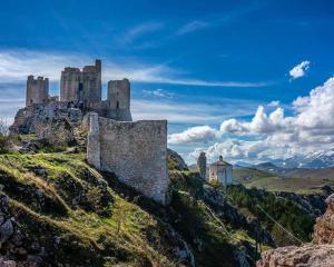 a castle on top of a hill with grass at Civico 62 - Case Vacanza D Andrea in Pratola Peligna