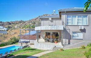 a home with a swimming pool and a house at Mountain Beauty in Mbabane