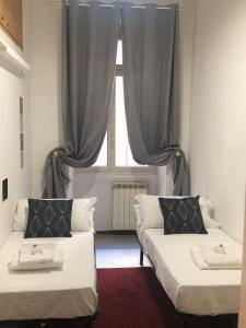 a room with two beds in front of a window at ROMAN APARTMENT in TRASTEVERE in Rome