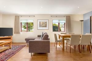 a living room with a table and a dining room at Wyndham Trenython Manor in Fowey