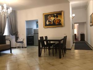 a dining room with a table and chairs and a painting on the wall at ROMAN APARTMENT in TRASTEVERE in Rome