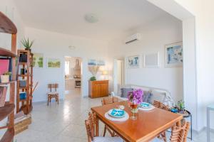 Un comedor y una sala de estar con mesa y sillas. en La vista mare da Rossella, en Specchiolla