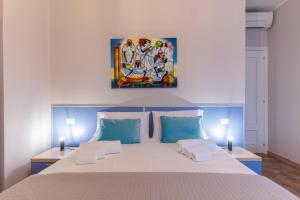 a bedroom with a bed with a painting on the wall at Teo House Beach in Taormina