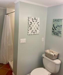 a bathroom with a toilet and a sign on the wall at Pearls Pad - Beautiful 1 bedroom apartment- 1 block to beach in Tybee Island