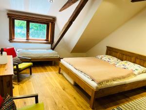 a attic bedroom with a bed and a chair at Chata Salamandra in Michalovce