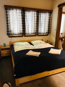 a bedroom with a large bed with two towels on it at Chata Salamandra in Michalovce