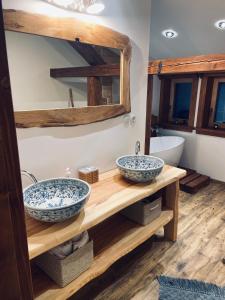 Baño con 2 lavabos en una estantería de madera en Chata Salamandra, en Michalovce