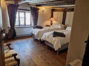 een slaapkamer met 2 bedden en een groot raam bij Remarkable 4-Bed Cottage in Cearleon in Newport