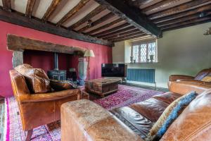 a living room with leather furniture and a fireplace at Remarkable 4-Bed Cottage in Cearleon in Newport