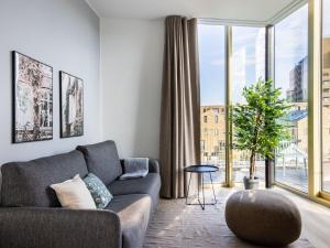 a living room with a couch and a large window at limehome Eindhoven Gashouder in Eindhoven