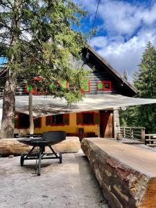 een picknicktafel voor een gebouw met een trein bij Tonkina koča in Kranjska Gora