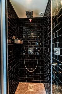 a black tiled bathroom with a shower with a glass door at Wonder Duplex 7 in Toulouse