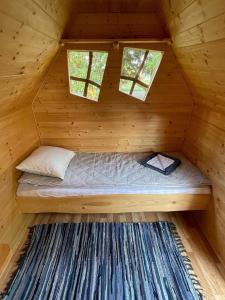Ce lit se trouve dans une cabane en rondins dotée de 2 fenêtres. dans l'établissement Künkaotsa, à Värati