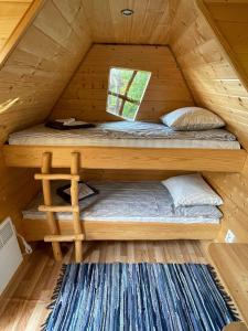 Ce lit superposé se trouve dans une cabane en bois dotée d'une fenêtre. dans l'établissement Künkaotsa, à Värati