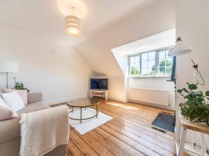 a living room with a couch and a table at Pass the Keys Victorian Flat A Stones Throw From Hampton Court in East Molesey