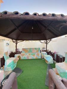 a room with chairs and a table with green grass at Private Cottage in Sharjah