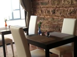 a dining room with a black table and white chairs at Art & Jazz Hotel in Catania