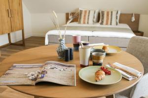 a table with plates of food and a book at Slufterhoeve in De Cocksdorp