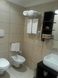 a white bathroom with a toilet and a sink at Art & Jazz Hotel in Catania