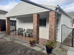 a covered patio with two chairs and a table at Covenant Place in Cape Town