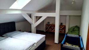 Schlafzimmer im Dachgeschoss mit 2 Betten und einem Stuhl in der Unterkunft Apartmán 17, Vysoké Tatry, Dolný Smokovec in Dolný Smokovec