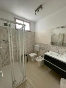 La salle de bains est pourvue d'une douche, de toilettes et d'un lavabo. dans l'établissement Appartamento LA ROTONDA, à Milano Marittima