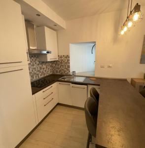 a kitchen with white cabinets and a counter top at Appartamento LA ROTONDA in Milano Marittima