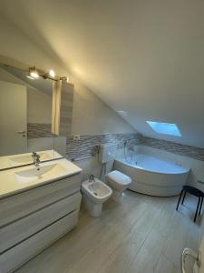 a bathroom with a tub and a toilet and a sink at Appartamento LA ROTONDA in Milano Marittima