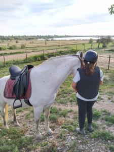 Uma mulher está ao lado de um cavalo branco. em El Niu de l'Estany em Ivars d'Urgell