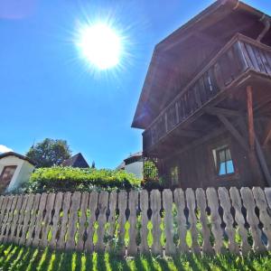 uma casa com o sol atrás de uma cerca de madeira em Chalet Maurer em Cadipietra