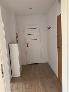 een lege kamer met een deur en een houten vloer bij Wiśnia in Malbork