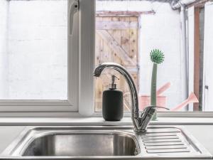 a kitchen sink with a soap dispenser next to a window at Pass the Keys Bright Airy 2 BR Home Great Location in Belfast