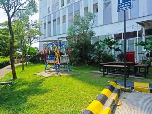 einen Spielplatz in einem Park neben einem Gebäude in der Unterkunft OYO 91593 San San Rooms Apartment Gunung Putri Square in Parungdengdek