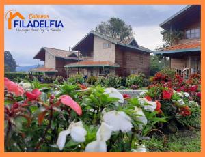 ein Bild eines Gartens mit Blumen vor einem Haus in der Unterkunft Cabañas Filadelfia in Santa Rosa de Cabal