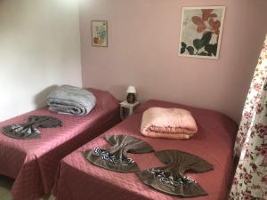 Pousada Recanto dos Arcos في كونسيرفاتوريا: سريرين في غرفة ذات أغطية وردية